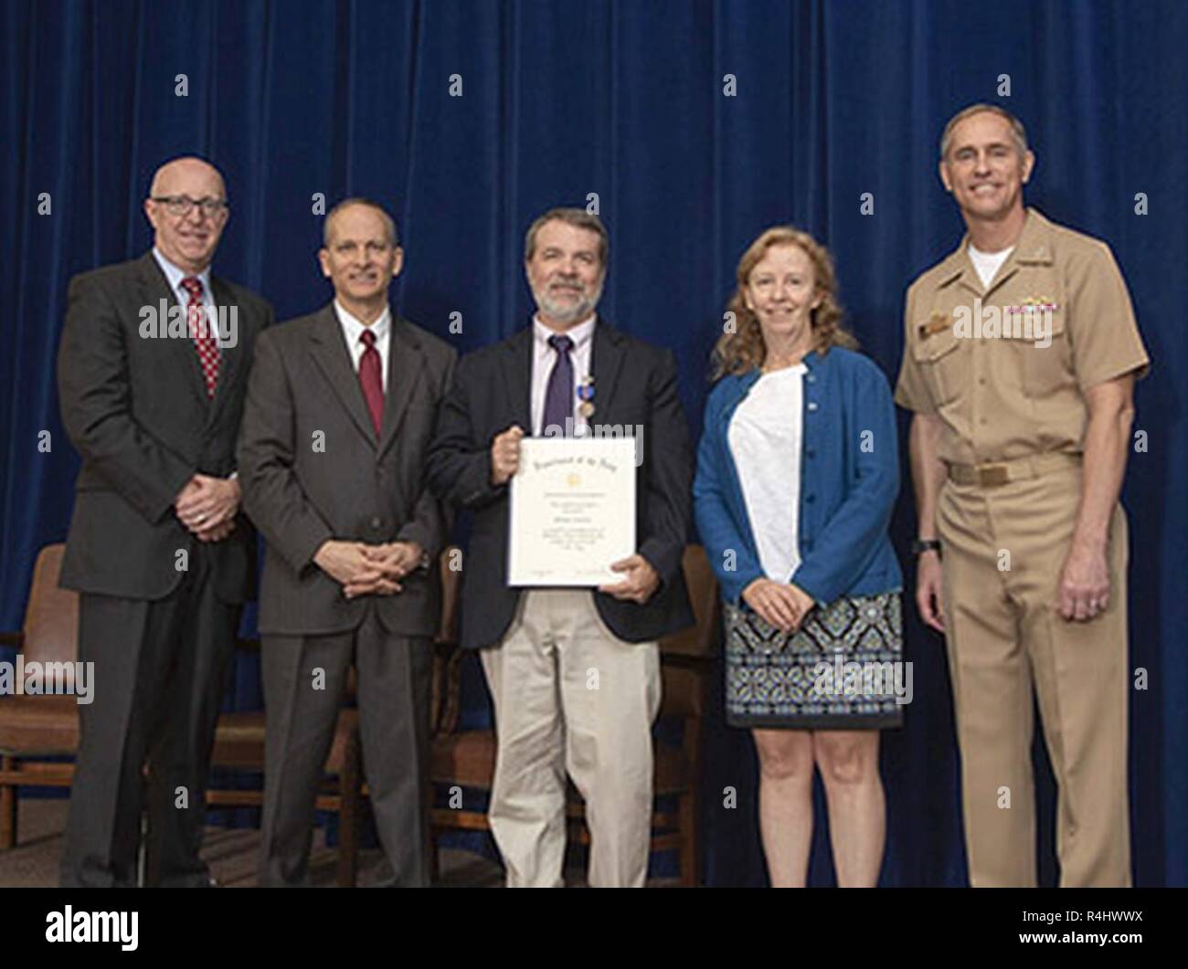 Thomas Downie (center) displays his Department of the Navy Meritorious Civilian Service Award that he received during an Oct. 1 awards ceremony. He is flanked by Donald McCormack (from left), Executive Director, Naval Surface and Undersea Warfare Centers; Ron Vien, NUWC Newport Technical Director, Thomas's wife, Deborah, and Capt. Michael Coughlin, NUWC Newport commanding officer. Stock Photo