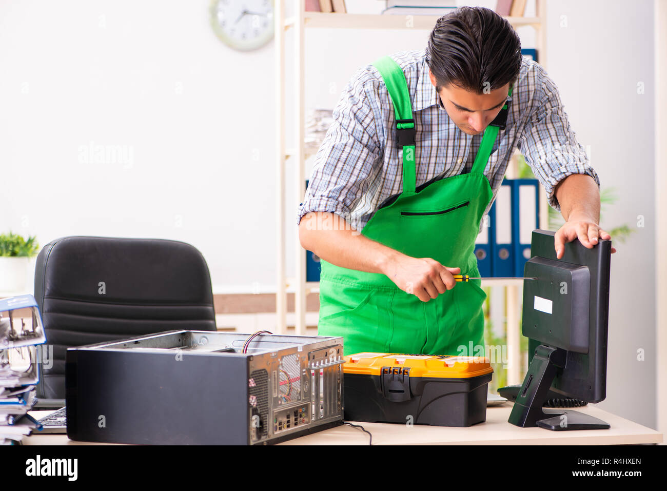 Young engineer repairing broken computer at the office Stock Photo - Alamy