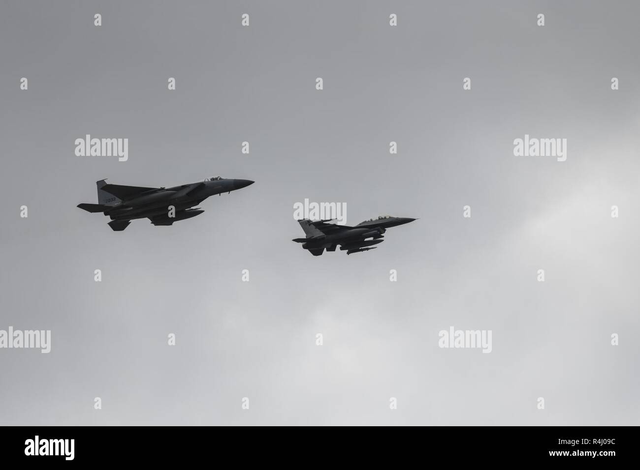 An F-16 Fighting Falcon and an F-15 Eagle, assigned to Eglin Air Force Base, Florida, participate in an aerial demonstration at Hurlburt Field, Florida, Oct. 26, 2018. During the event, 12 aircraft from across the Air Force participated in an aerial demonstration in honor of Master Sgt. John Chapman, a combat controller who made the ultimate sacrifice during an intense battle in the mountains of Afghanistan. Chapman was posthumously awarded the Medal of Honor on Aug. 22, 2018. Stock Photo