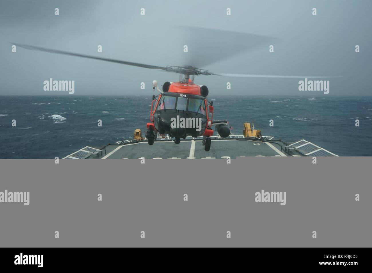 A Coast Guard rescue helicopter takes off from the deck of the Cutter