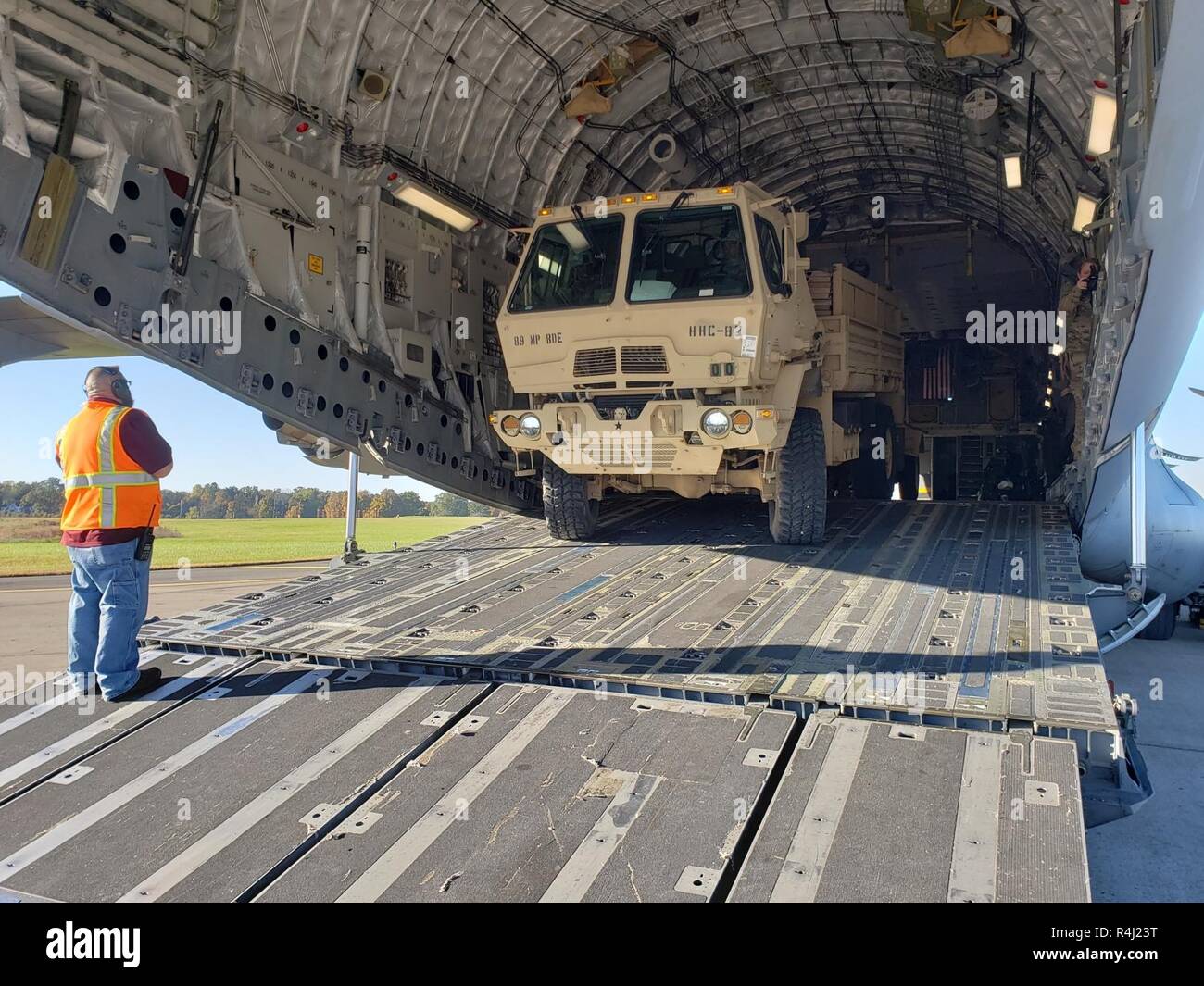 Richard Wolfe, Unit Movement Coordinator for Fort Knox, Kentucky, provides directions as Pfc. Emmanuel Cook, Headquarters and Headquarters Company, 89th Military Police Brigade, Task Force Griffin, loads a Light Medium Tactical Vehicle on a C-17 aircraft, October 29, 2018. Soldiers from Task Force Griffin are deploying to the Southwest Border Region to support and enable Department of Homeland Security and other law enforcement agencies as they conduct coordinated efforts to secure our southwest border. Stock Photo