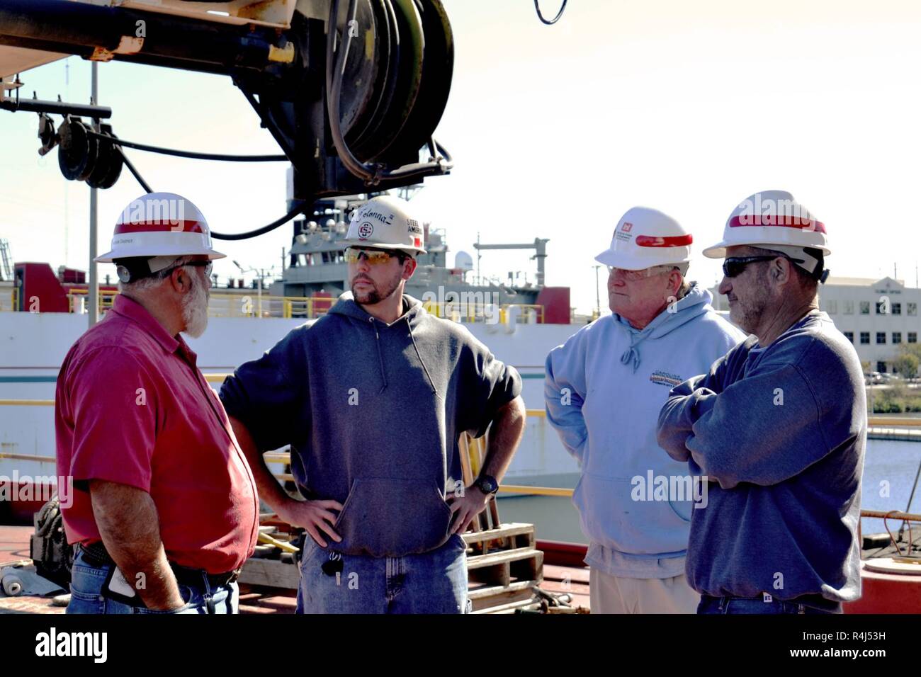 From left to right, Scott Titus, U.S. Army Corps of Engineers Norfolk District port engineer, Will Colonna of Colonna's Shipyard Inc., Glen Boykin, derrick boat Elizabeth marine machinery mechanic, and Richard Bruton, DB Elizabeth captain, stand on the deck of the DB Elizabeth as it sits dry docked at Colonna's Shipyard Inc., Norfolk, Va., Oct. 29, 2018. The boat, part of the USACE fleet, is often used for debris removal in and around its home waters of Norfolk, Va. Stock Photo