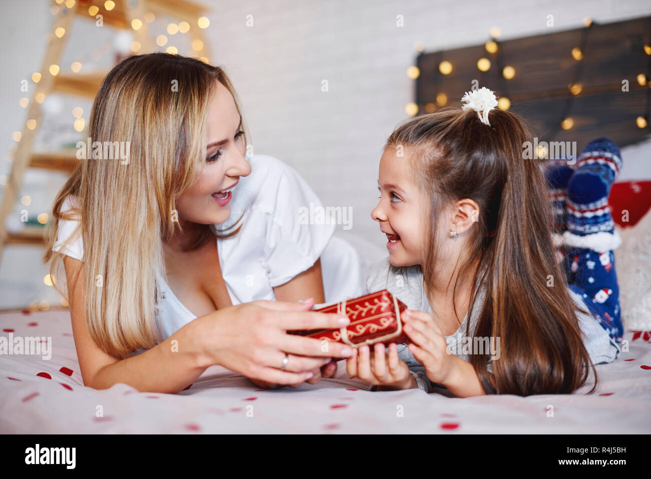 Girl giving christmas present to her mom Stock Photo