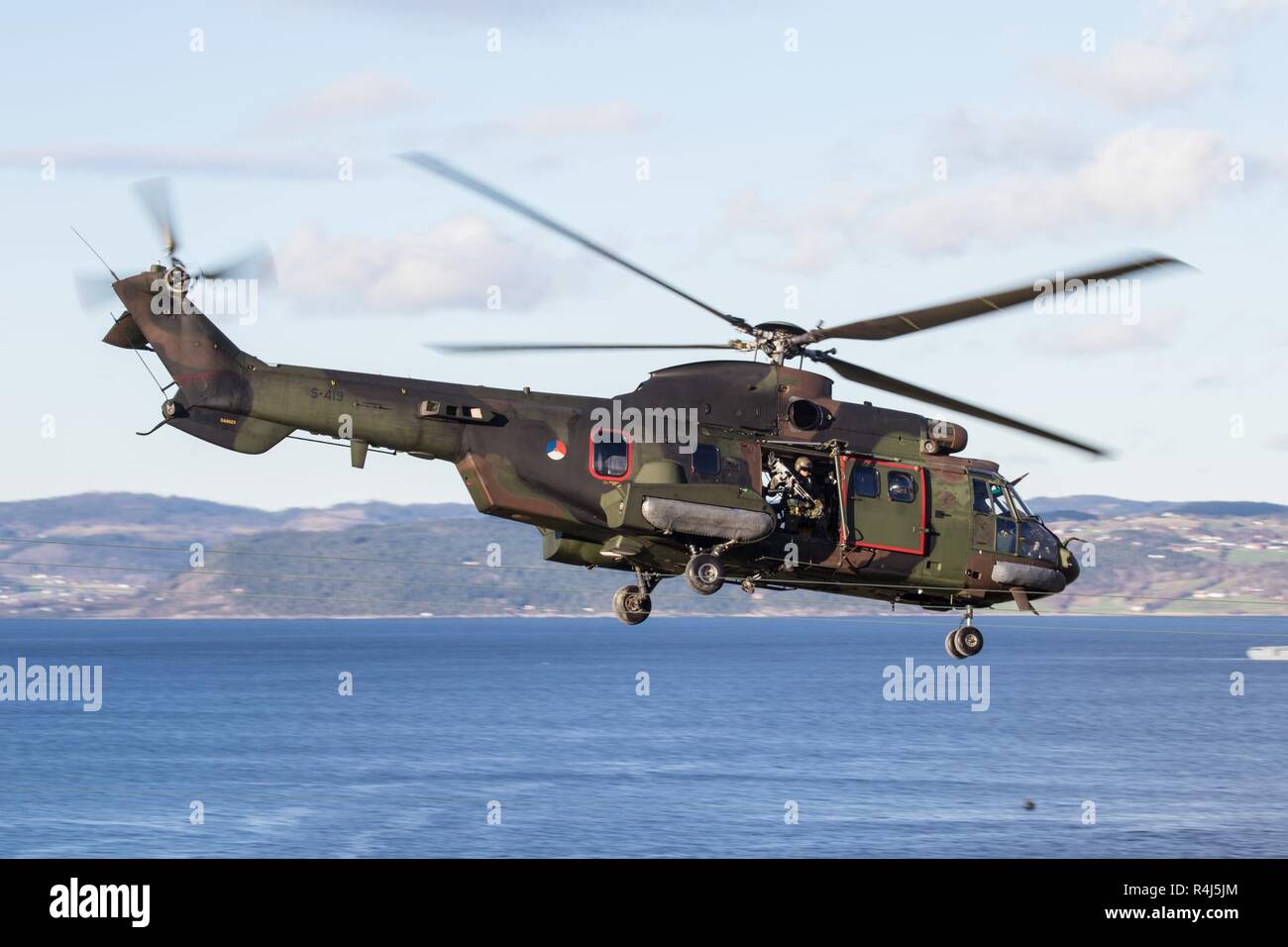 A Dutch AS532 Super Puma helicopter securities the landing of infantrymen  on the beach of Trondheim Fjord, in Norway, during exercise Trident  Juncture 18. With around 50,000 personnel participating in Trident Juncture