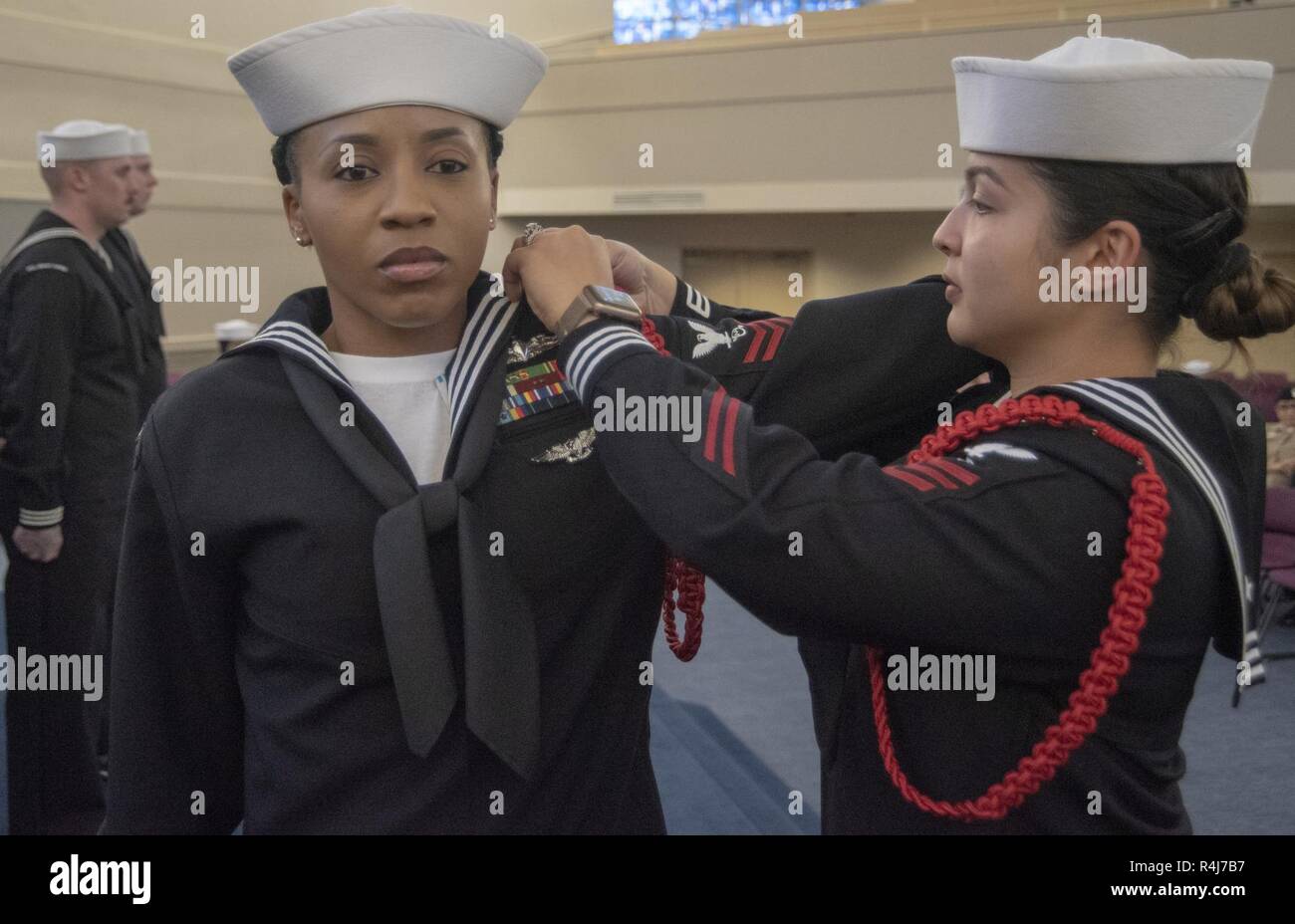 GREAT LAKES, Ill. (Nov. 1, 2018) Operations Specialist 1st Class Ranette Brown receives her recruit division commander (RDC) aiguillette, commonly referred to as a 'red rope,' during an RDC 'C' School graduation ceremony inside the Recruit Memorial Chapel at Recruit Training Command. More than 30,000 recruits graduate annually from the Navy's only boot camp. Stock Photo