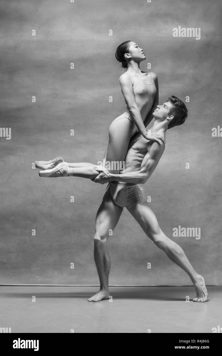 Couple of ballet dancers posing over gray background Stock Photo