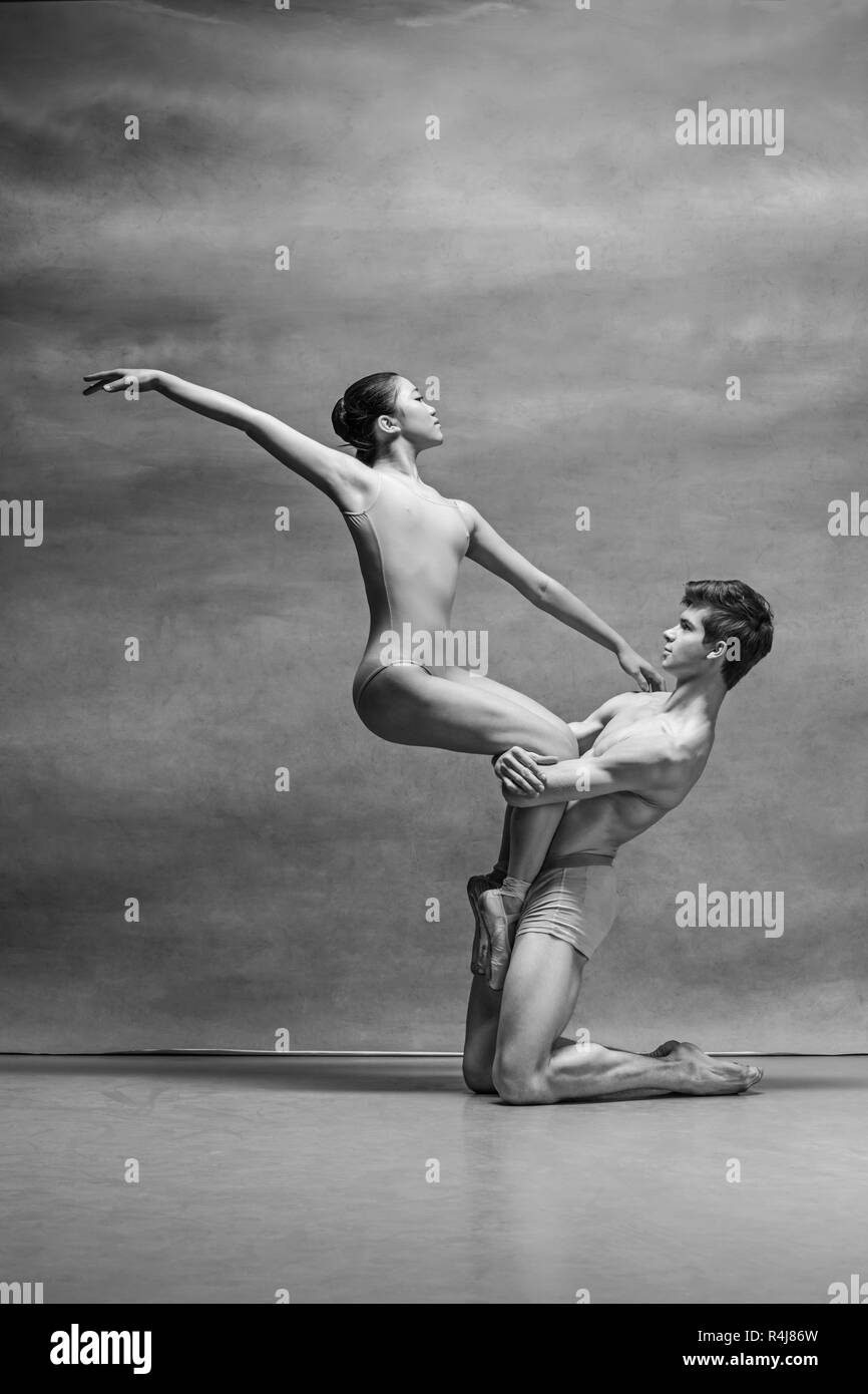 Couple of ballet dancers posing over gray background Stock Photo