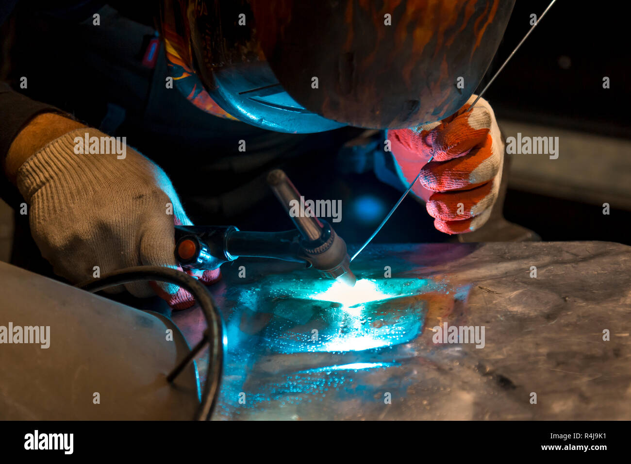 Argon-arc welding welder at the workplace welds the part Stock Photo - Alamy