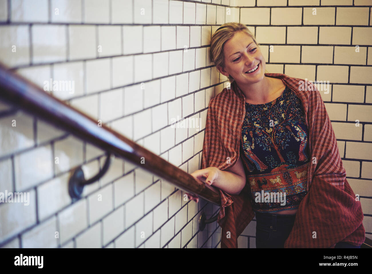 Mid adult woman standing in a stairwell in Stockholm, Sweden Stock Photo