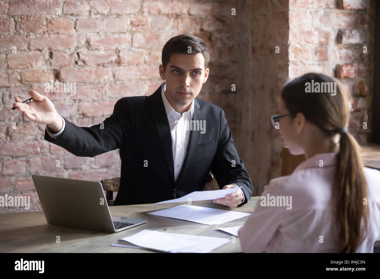 Annoyed boss points employee at door because of document error. Stock Photo