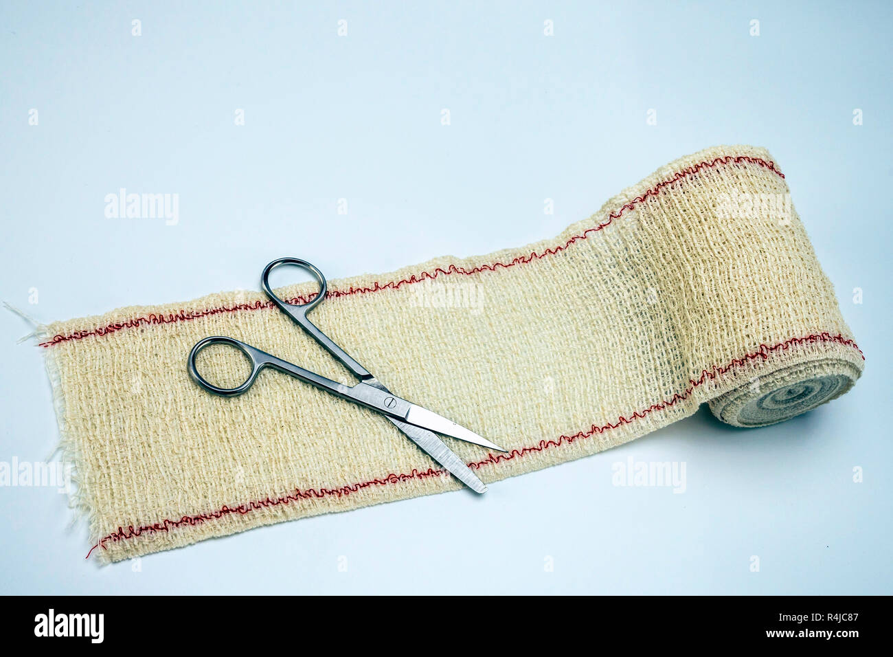 Surgical scissors on a bandage, conceptual image Stock Photo