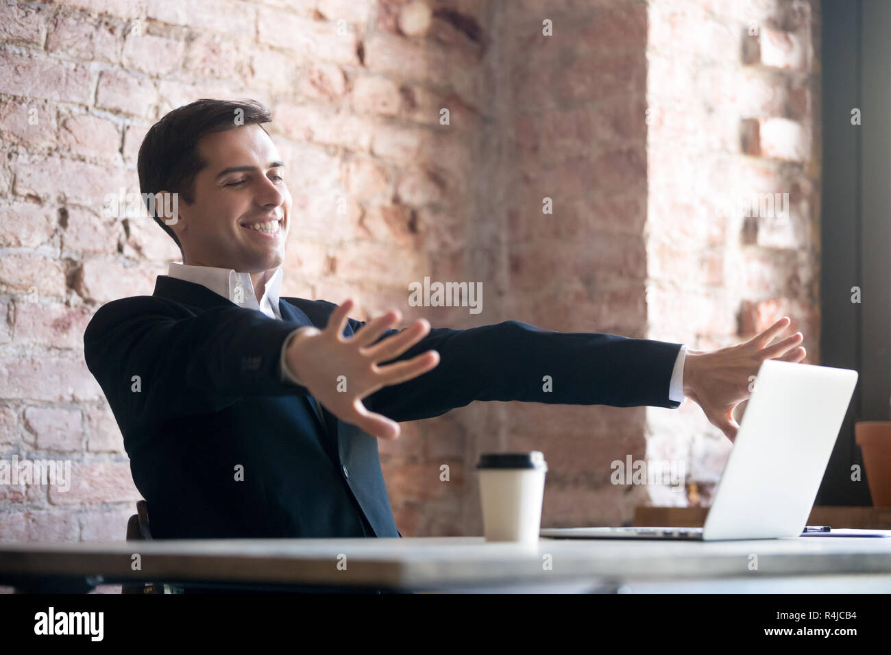 Smiling businessman doing relaxing exercise in workplace. Stock Photo