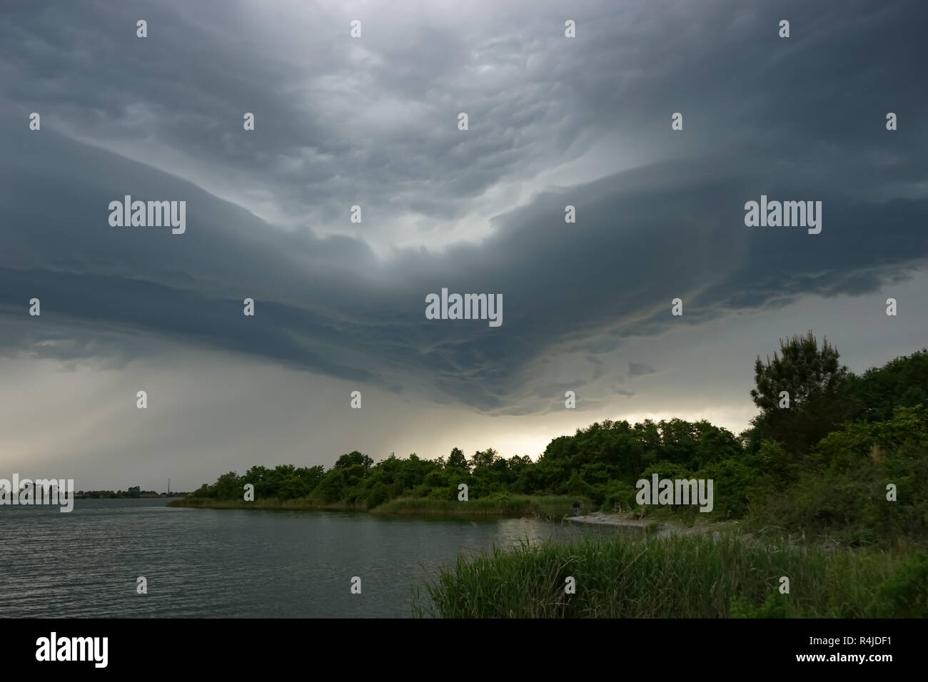 Dramatic landscape with storm clouds over the lake Stock Photo - Alamy