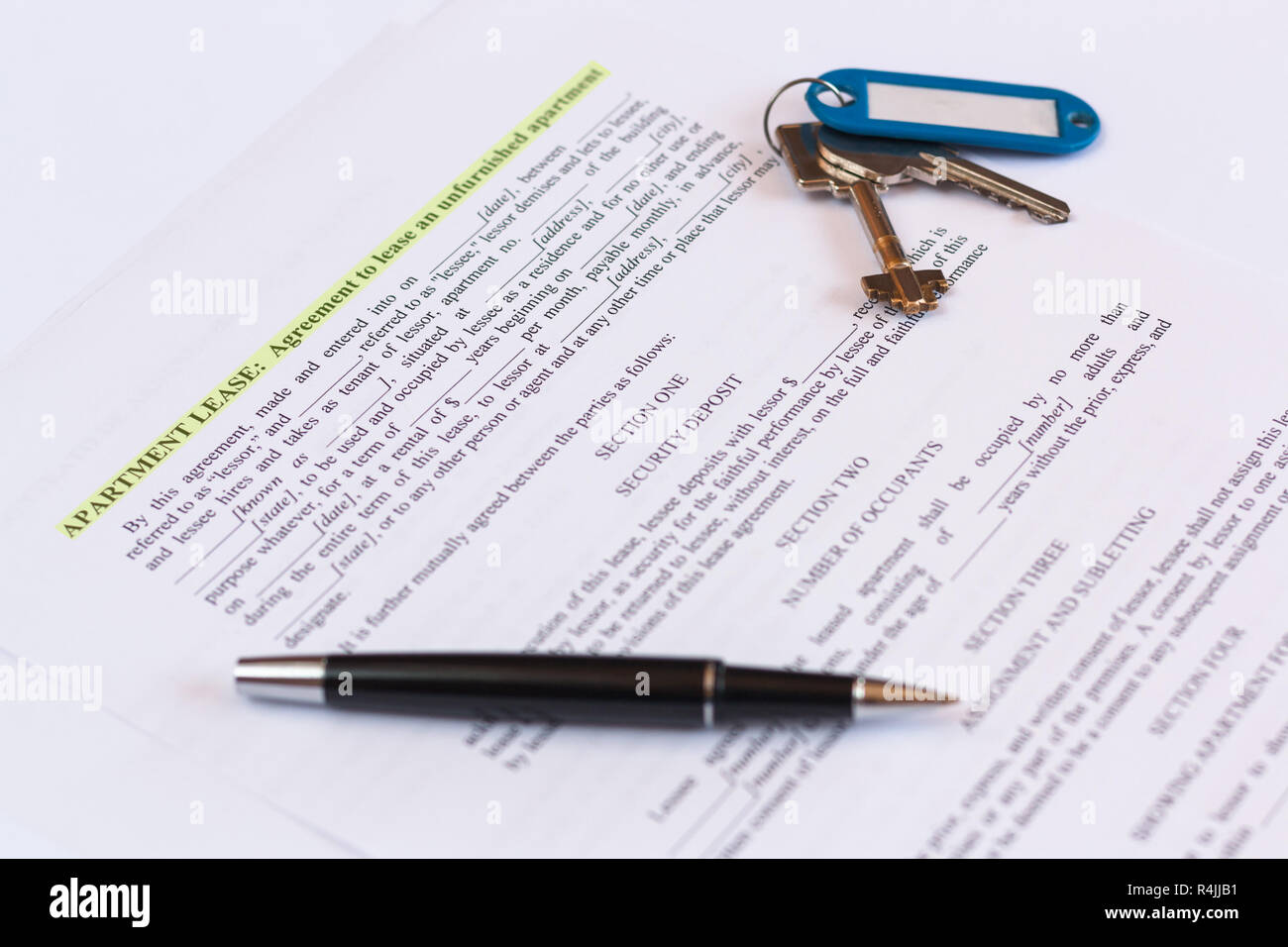 Lease / Rental agreement document with keys and pen. Contract in english. Stock Photo