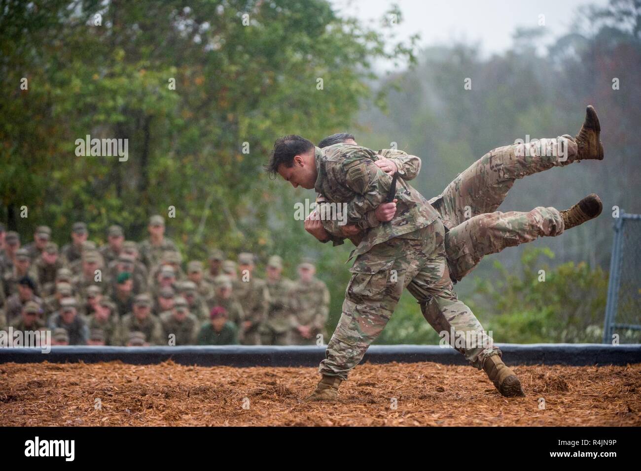 FORT BENNING, Ga. (Oct. 26, 2018) -- Two Soldiers with the Airborne and Ranger Training Brigade demonstrate hand-to-hand combat maneuvers during the Rangers In Action demonstration preceding a Ranger Course graduation. Under Secretary of the Army Ryan D. McCarthy speaks at the Airborne and Ranger Training Brigade ranger graduation at Victory Pond at Fort Benning, Georgia, Oct. 26. McCarthy, who served five years in the Army, was involved in combat operations in Afghanistan in support of Operation Enduring Freedom with the 75th Ranger Regiment, U.S. Special Operations Command. Stock Photo