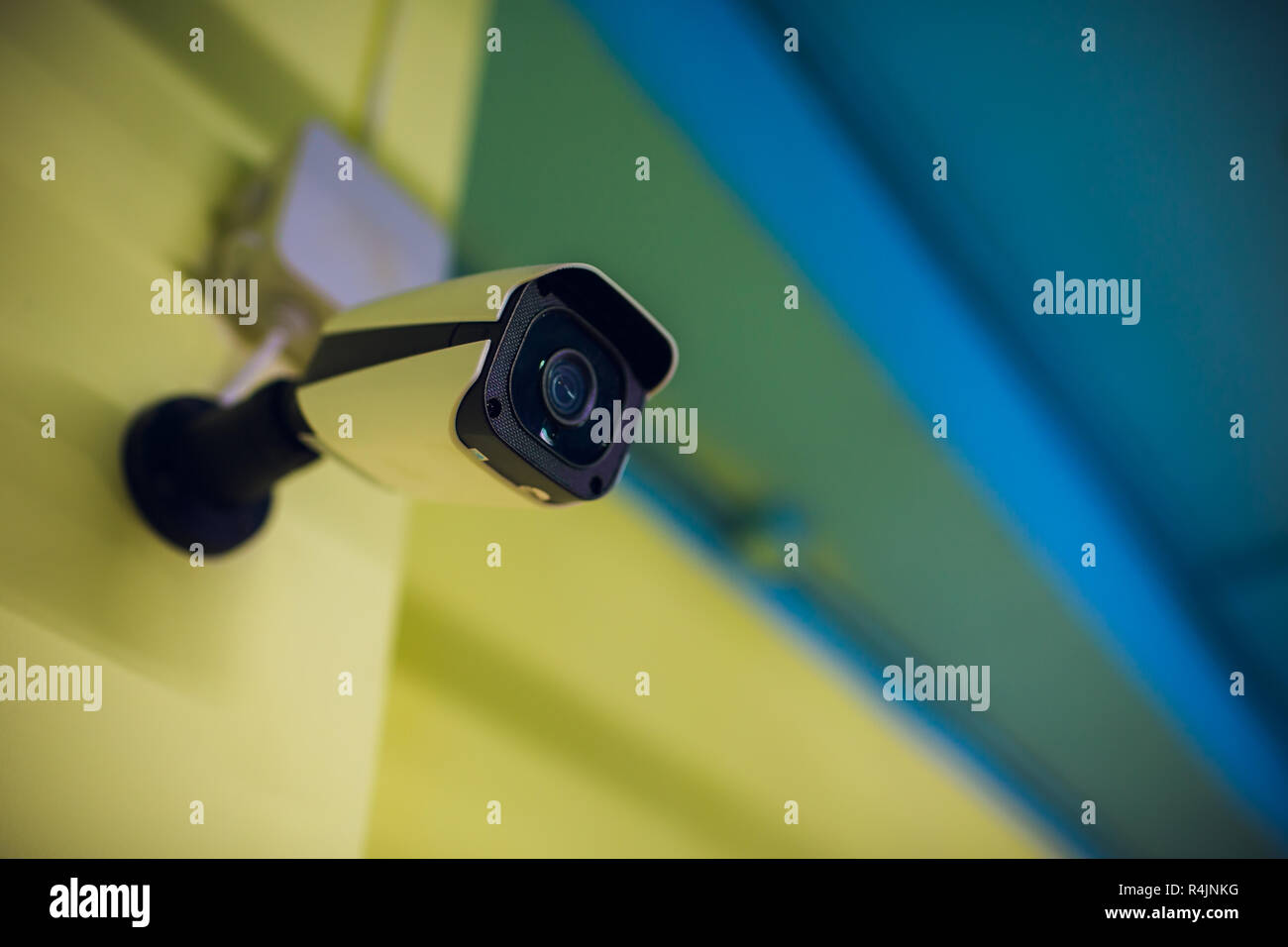 Modern CCTV camera on a wall. A blurred night cityscape background