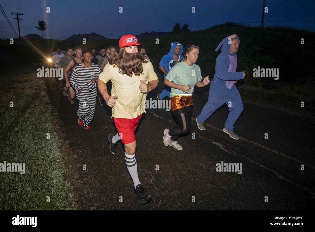 U.S. Marines and Sailors with Aviation Ordnance, Marine Aviation Logistics Squadron 24, Marine Aircraft Group 24, conducted a motivated run on Marine Corps Air Station Kaneohe Bay, Marine Corps Base Hawaii, Oct. 31, 2018. U.S. Service members with Aviation Ordnance dressed up for a unit run to celebrate Halloween. Stock Photo