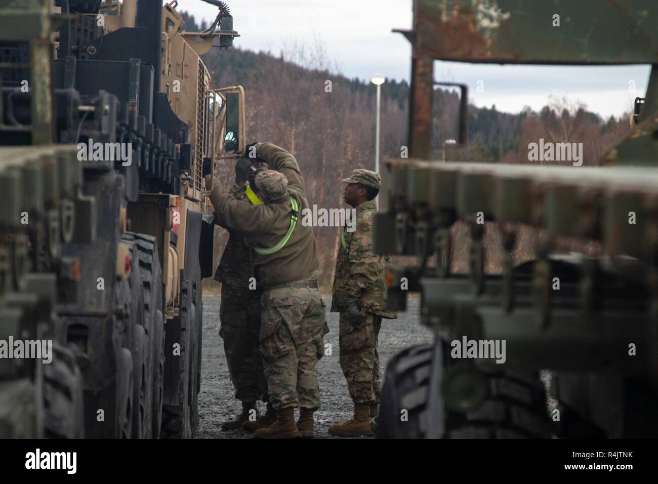 U.S. Army Soldiers assigned to the 51st Composite Truck Company, 18th Combat Sustainment Support Battalion, 16th Sustainment Brigade, fix a broken mirror during Exercise Trident Juncture 18, at Levanger, Norway, Oct. 31, 2018.    Trident Juncture 18 is a comprehensive exercise promoting interoperability and cohesion between the United States and its European Allies and partners to enhance readiness and ensure the continued peace and stability in the region. Stock Photo