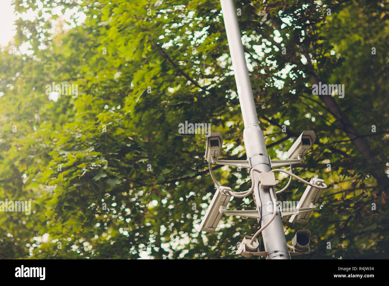 Cluster of security cameras on a lamppost in an old public Park on the