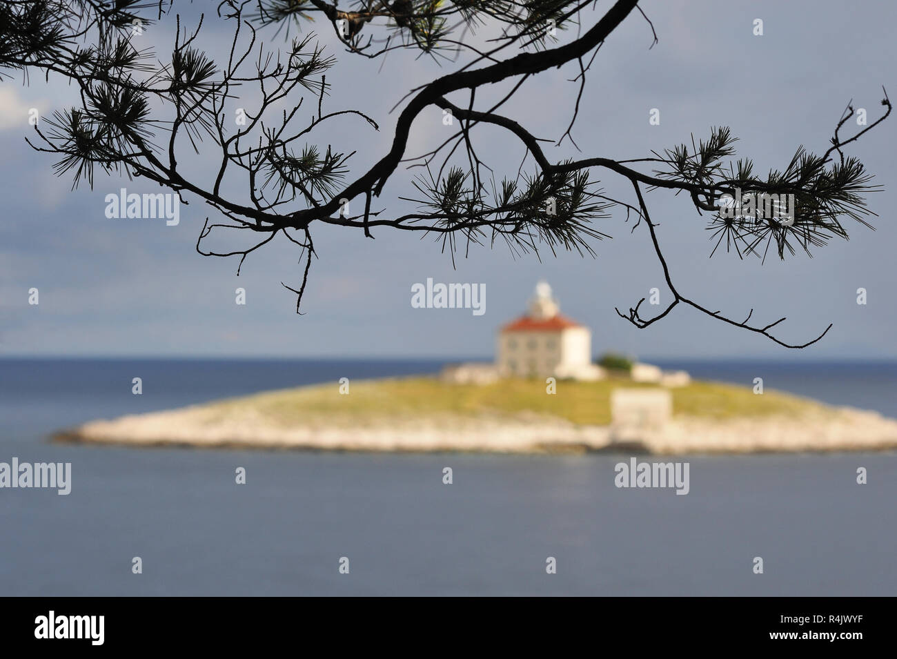 lighthouse on the island in front of hvar with branches Stock Photo