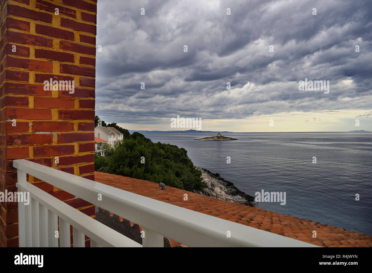 dark clouds over the lighthouse on the island Stock Photo