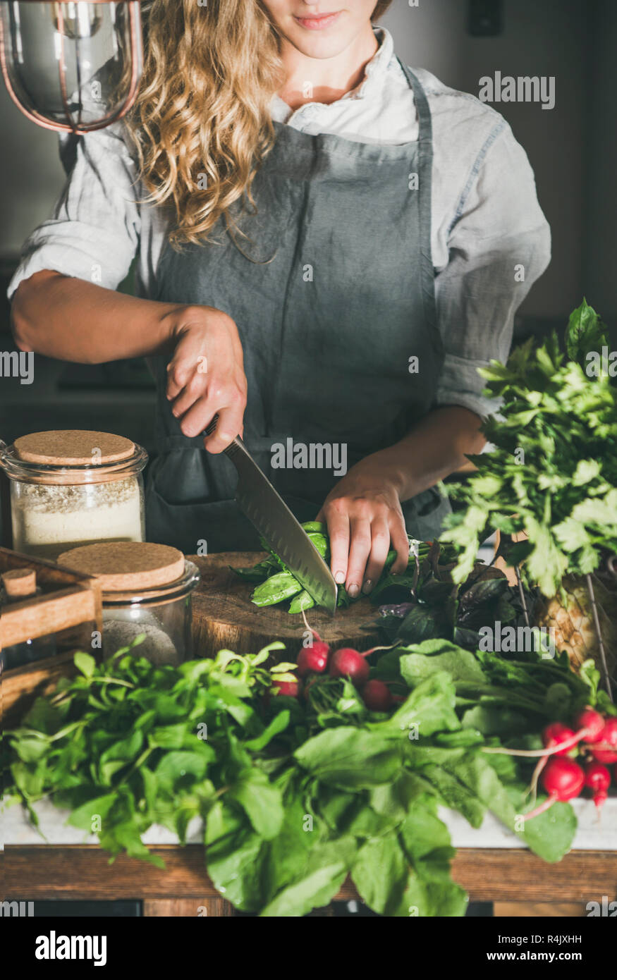 Fall seasonal vegetarian, vegan dinner cooking. Woman in linen apron