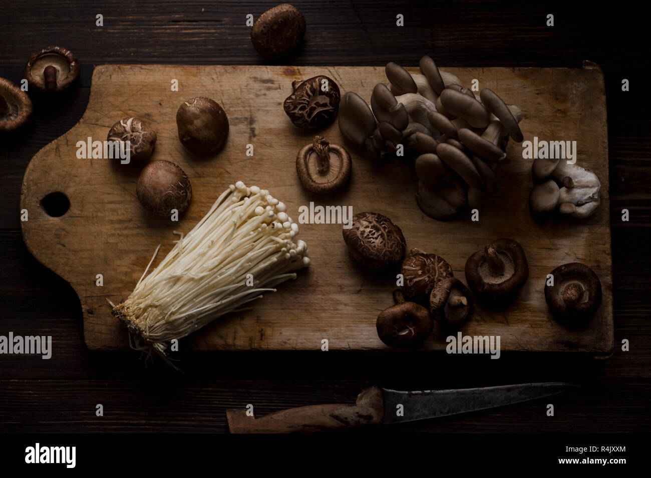 Enoki, shiitake and oyster mushrooms on cutting board Stock Photo Alamy