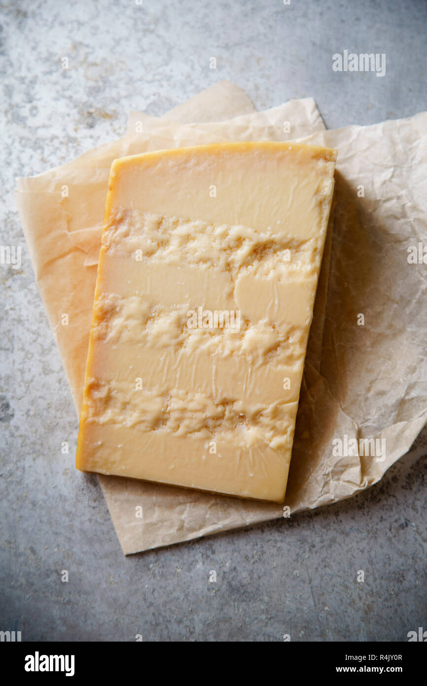 A block of parmesan cheese on parchment paper Stock Photo Alamy