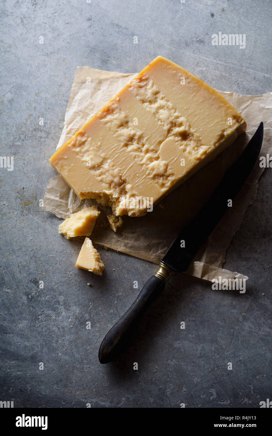 A block of parmesan cheese on parchment paper Stock Photo Alamy