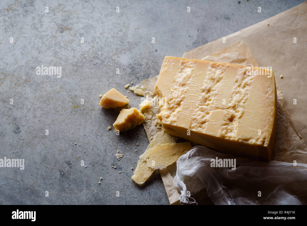 A block of parmesan cheese on parchment paper Stock Photo Alamy
