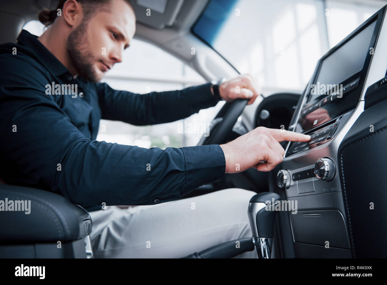 Close up view of a young man driving a car. Start a business trip. Test drive a new auto Stock Photo