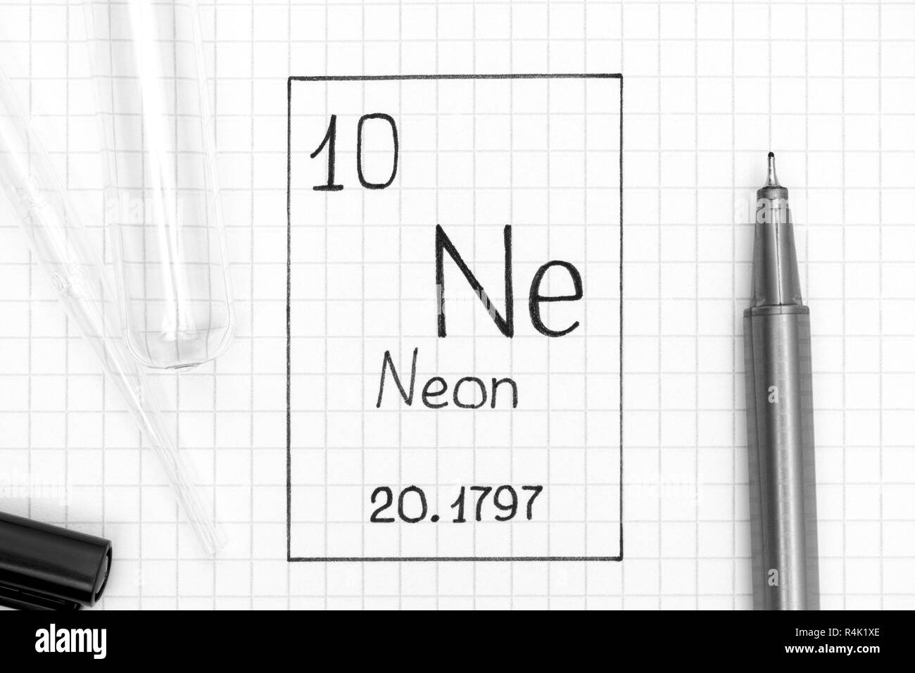 The Periodic table of elements. Handwriting chemical element Neon Ne with black pen, test tube and pipette. Close-up. Stock Photo
