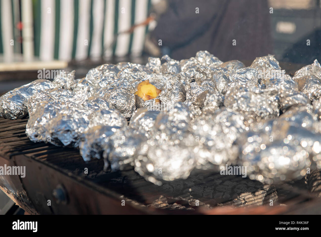 Small potatoes in foil on the grill Stock Photo Alamy