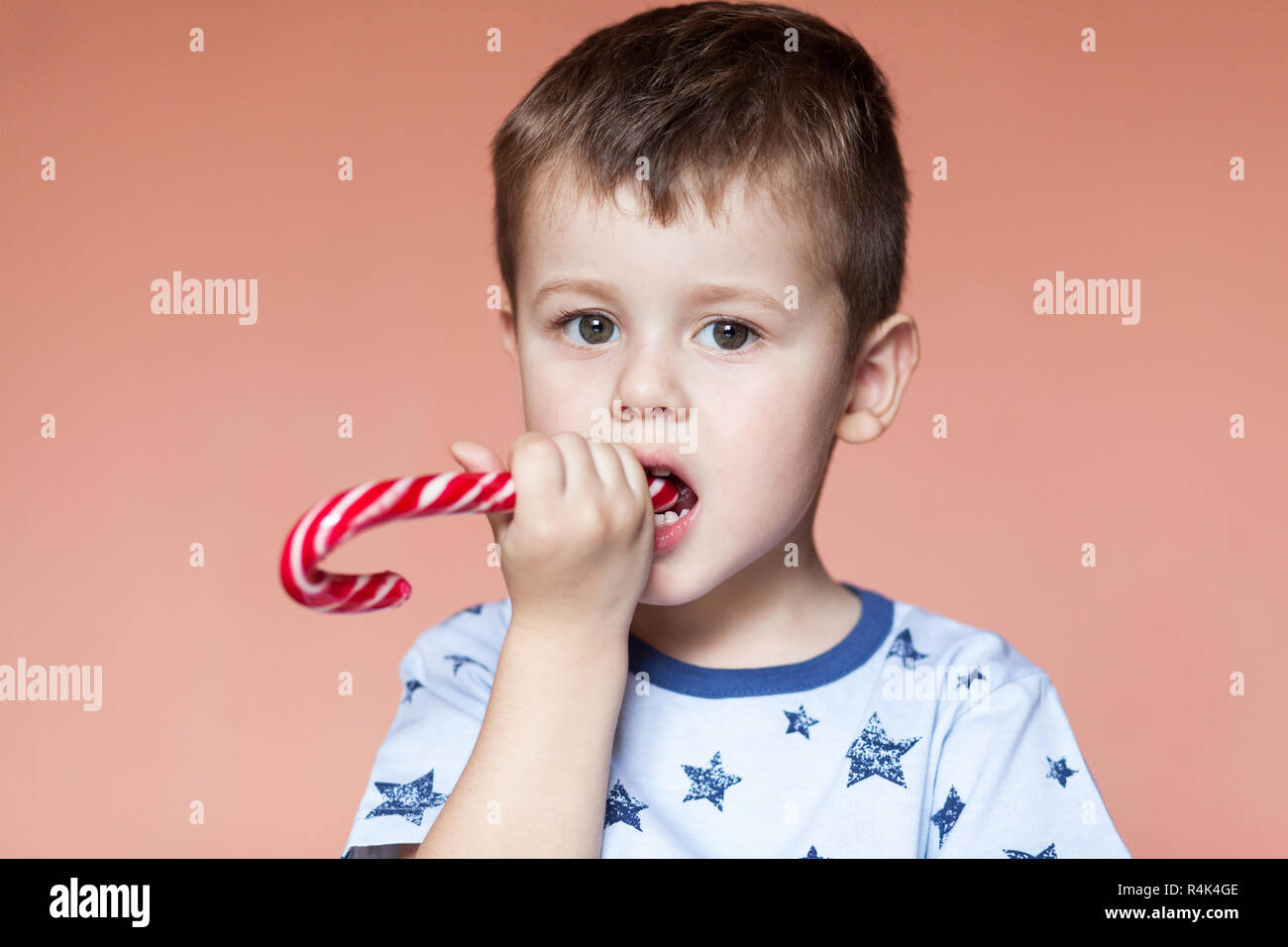 A cute boy eating candy sticks. Colored traditional handmade candy