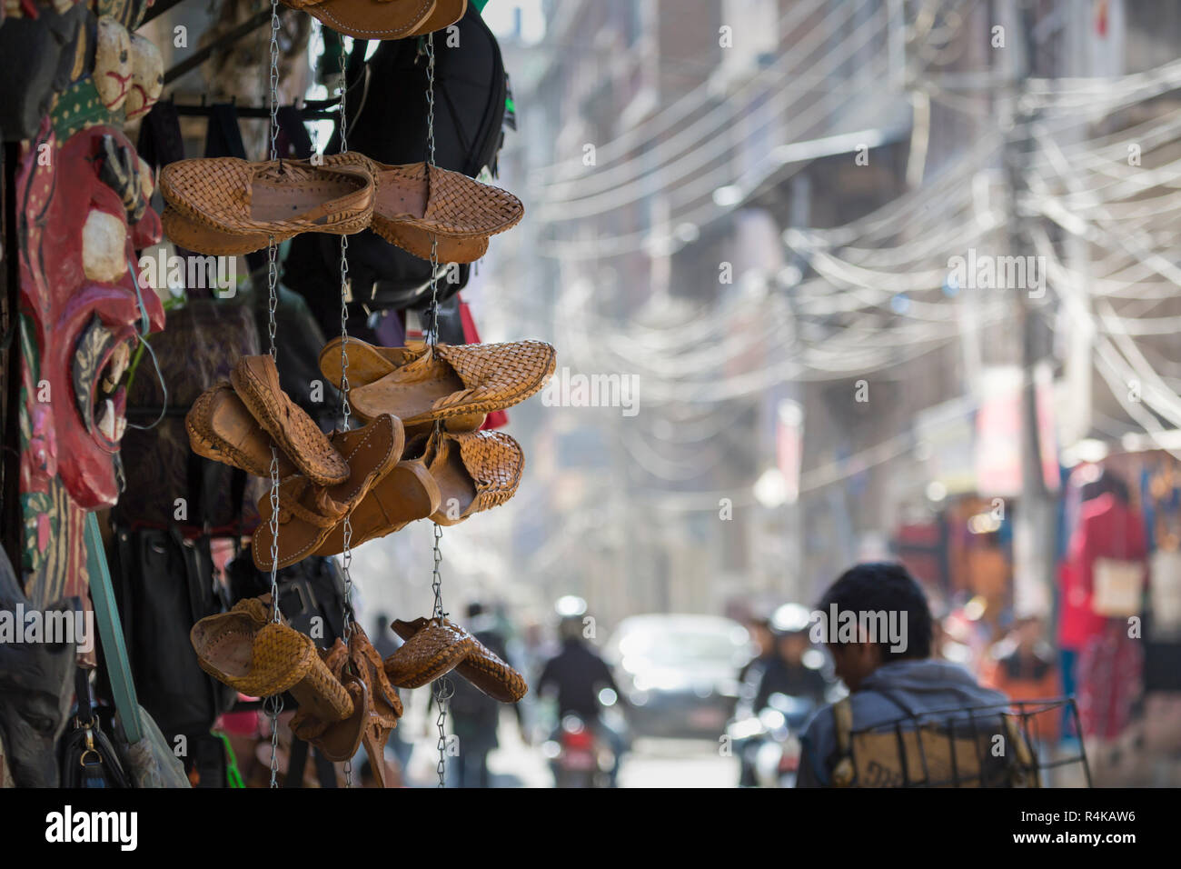 Traditional nepali hempen shoes and vest leaning against a red wall in