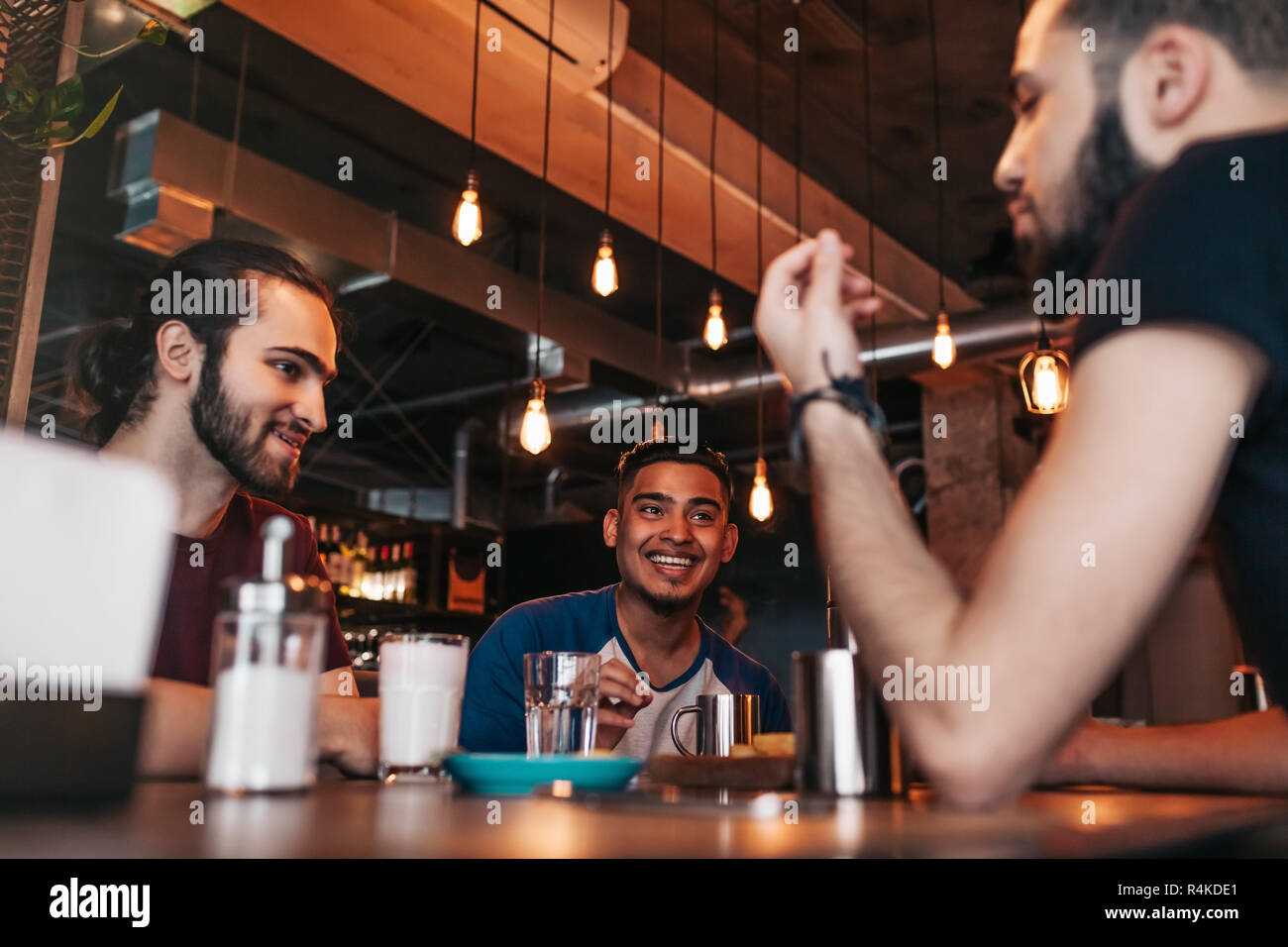 Happy arabian young men hanging in loft cafe. Best friends talking in ...
