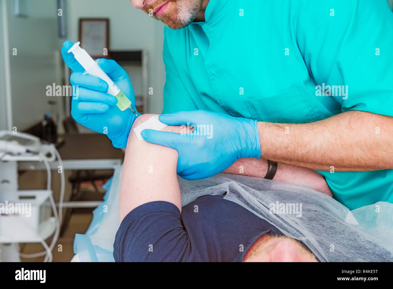 Close up Neurologist doctor makes an injection therapy (blockade) into elbow joint muscle of male patient. Alternative pain treatment concept. Selecti Stock Photo