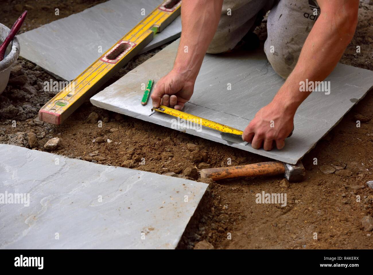 A builder measuring stone paving slabs Stock Photo Alamy