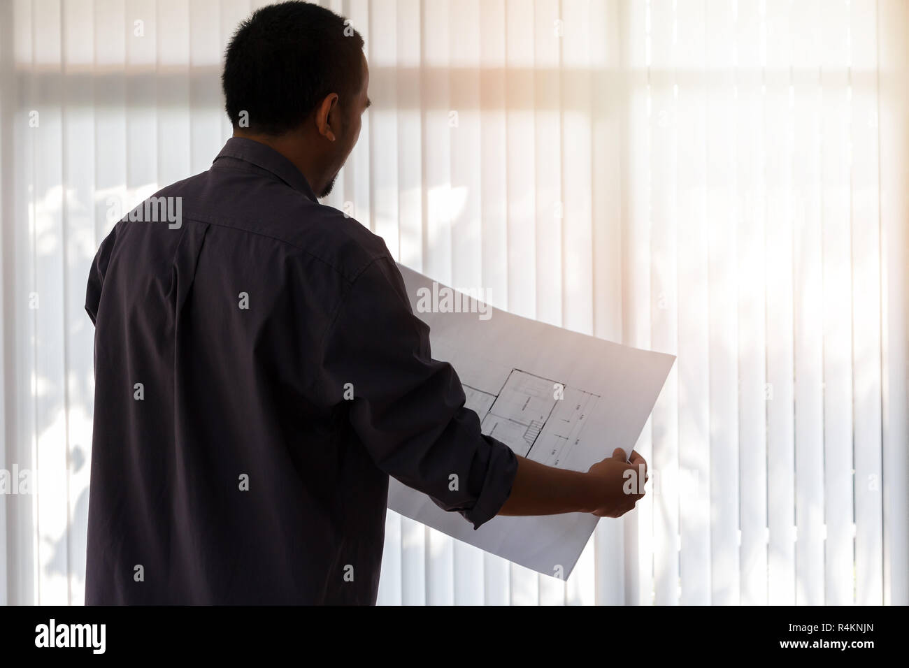 Architect working in a office. Engineer holding blueprint in office, architectural concept Stock Photo
