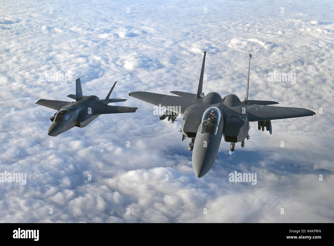 An RAF F-35B Lightning stealth jet (left) flies with a United States Air Force F-15 Strike Eagle over the English Channel during Operation Point Blank, which featured aerial capabilities from the RAF, United States Air Force and French Air Force. Stock Photo