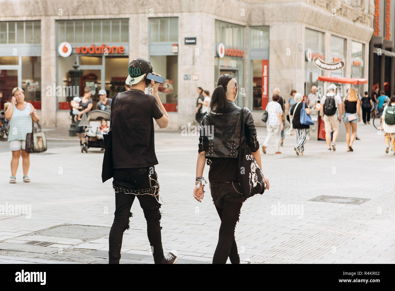 Germany, Leipzig, September 6, 2018: Young couple punks or friends walking down the street in Leipzig. He listens to music on the phone. Youth subculture. Stock Photo