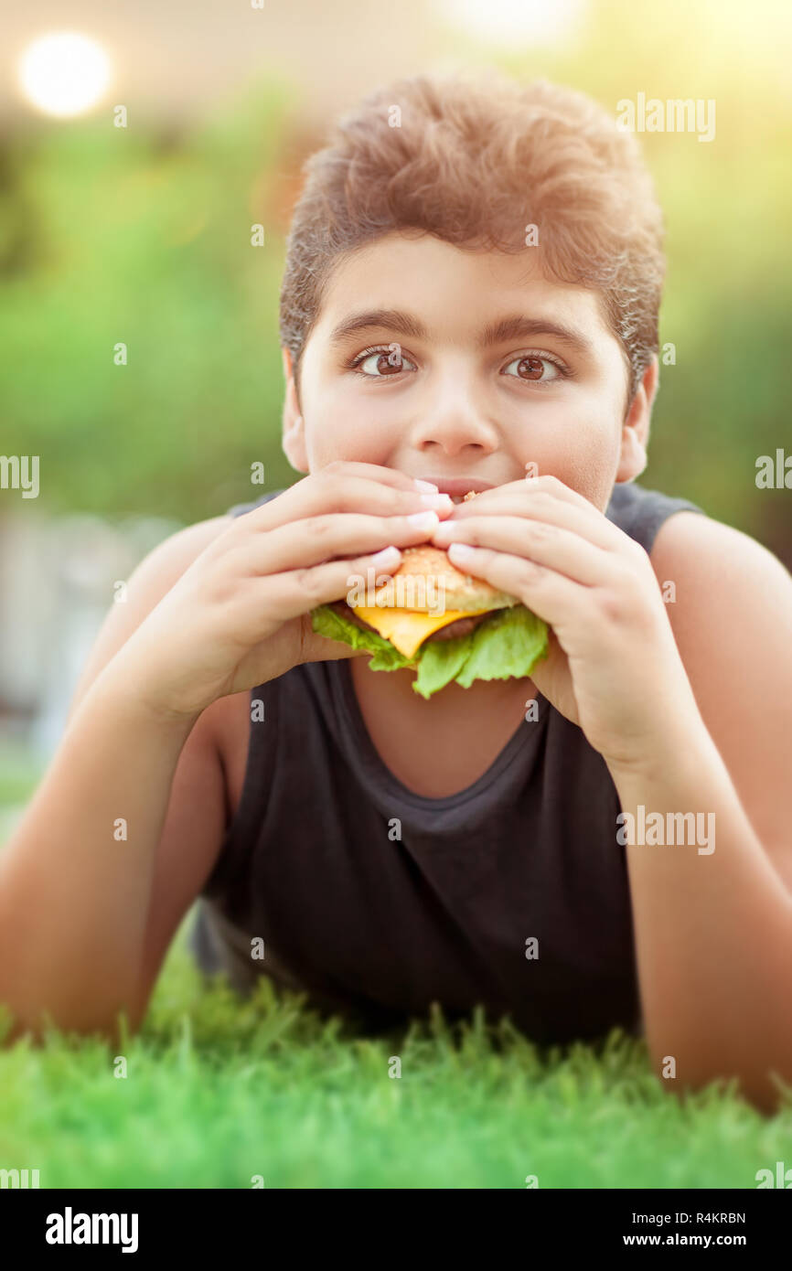 Teen boy eating burger Stock Photo