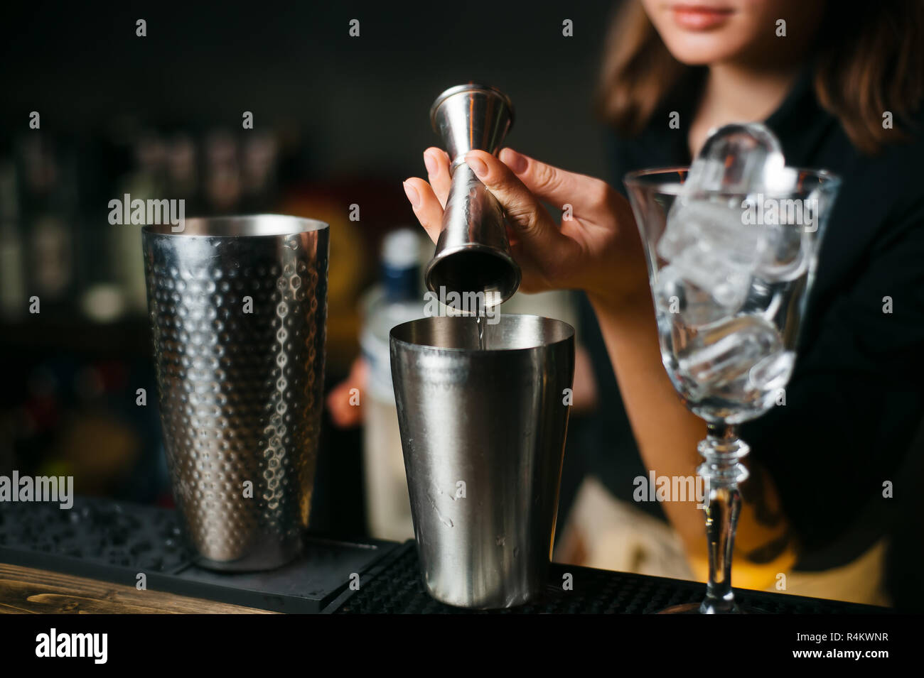 cocktail preparation. bartender coocks a beverage at bar counter. Stock Photo