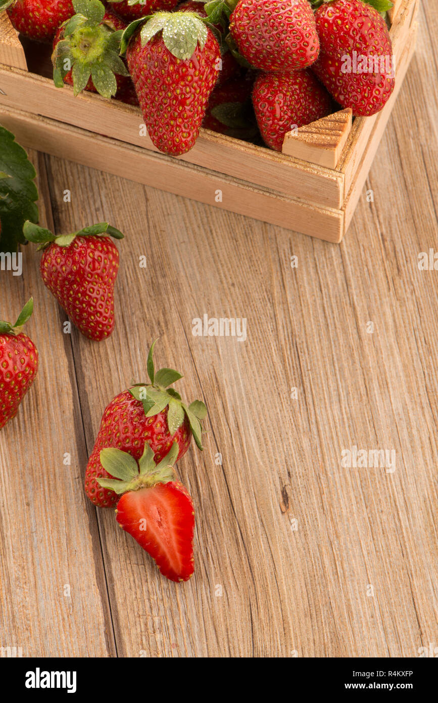 Strawberries over odl brown wooden table background Stock Photo - Alamy