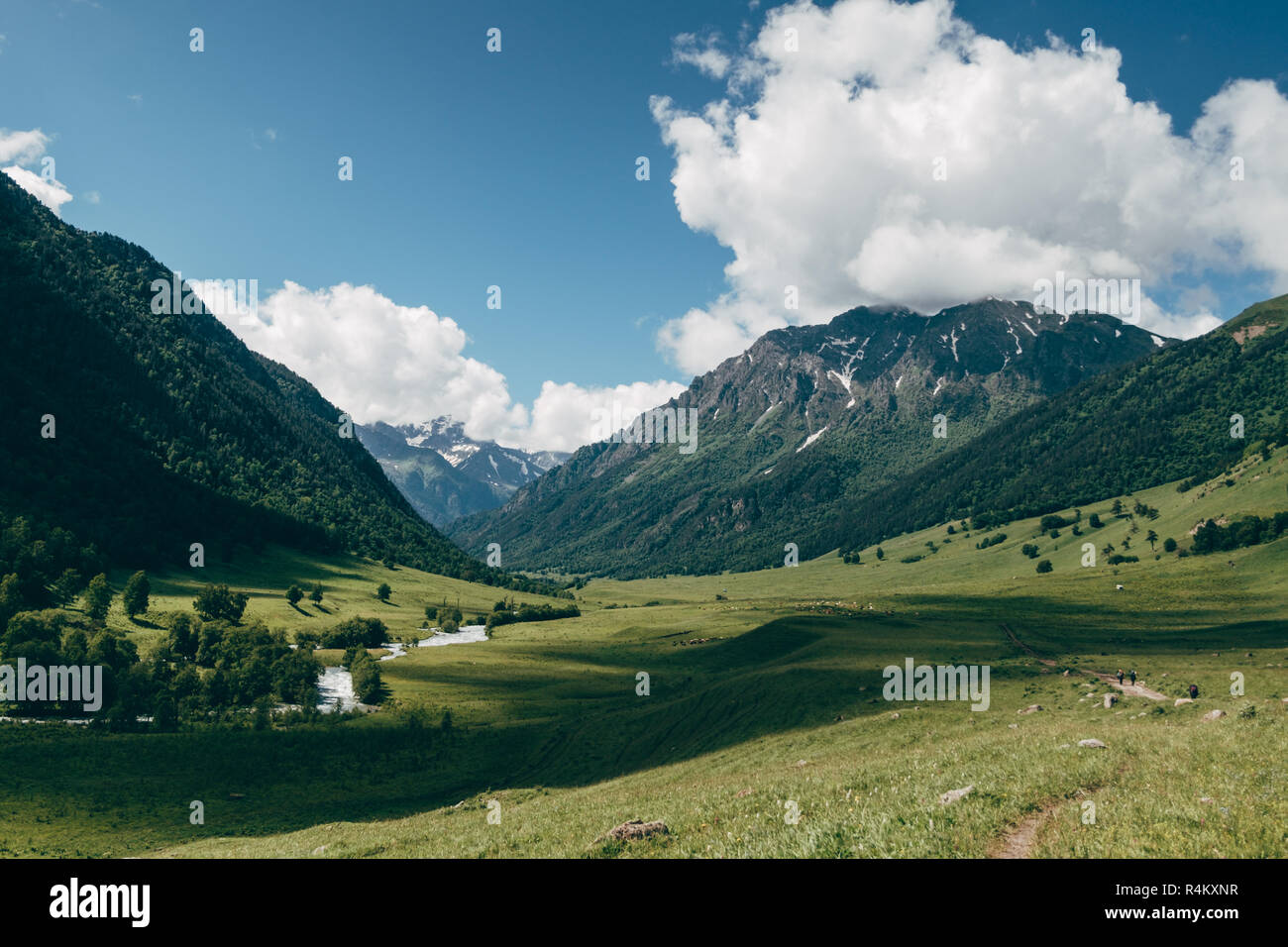 green mountain valley landscape with blue sky and white clouds. Deep ...