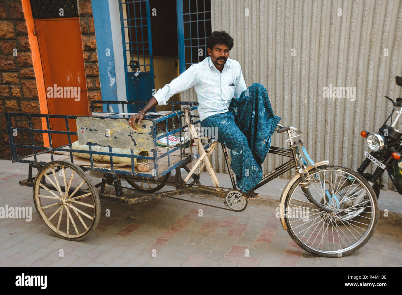 indian rickshaw man sits on his vehicle 23 february 2018 Madurai, India Stock Photo
