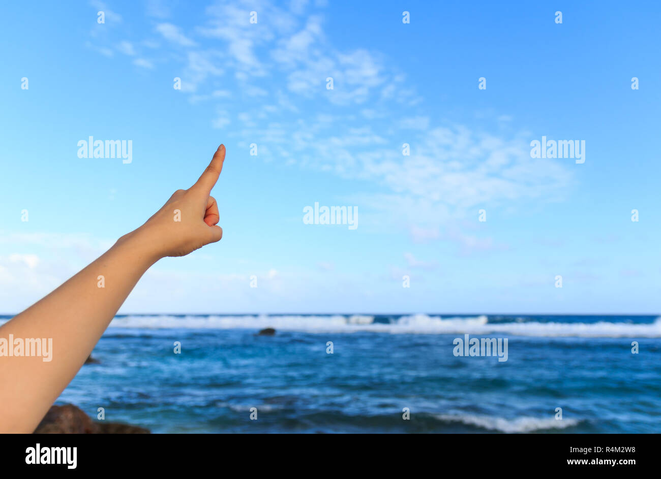 Hand against a blue sky background Stock Photo