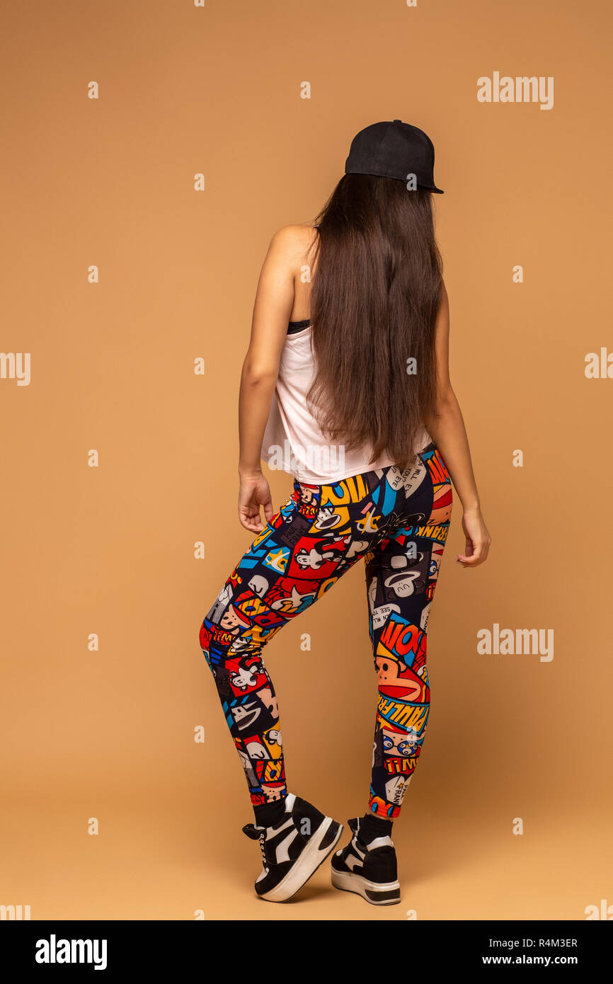 One attractive fit cute young woman wearing multi-colored leggings, white  jersey and cap. Modern style beautiful dancer working out, dancing. Full  len Stock Photo - Alamy
