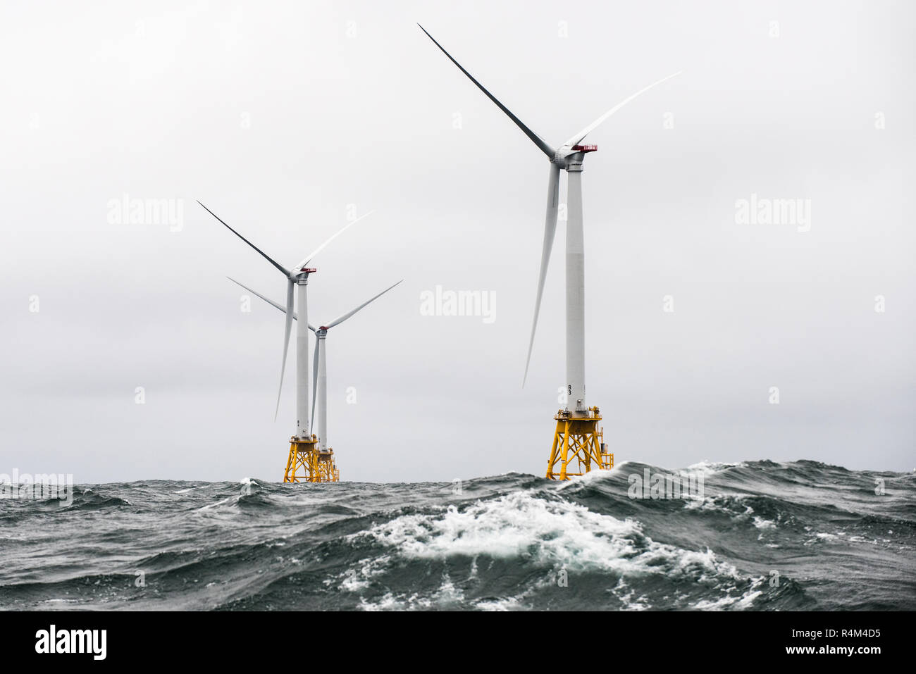 October 1, 2016 - Heavy seas engulf the Block Island Wind Farm, the first US offshore wind farm. The five Halide 6MW turbines were recently installed by Deepwater Wind, and are currently under commissioning. (Photo by Dennis Schroeder / NREL) Offshore wind power or offshore wind energy is the use of wind farms constructed in bodies of water, usually in the ocean on the continental shelf, to harvest wind energy to generate electricity. Higher wind speeds are available offshore compared to on land, so offshore wind power’s electricity generation is higher per amount of capacity installed, Stock Photo