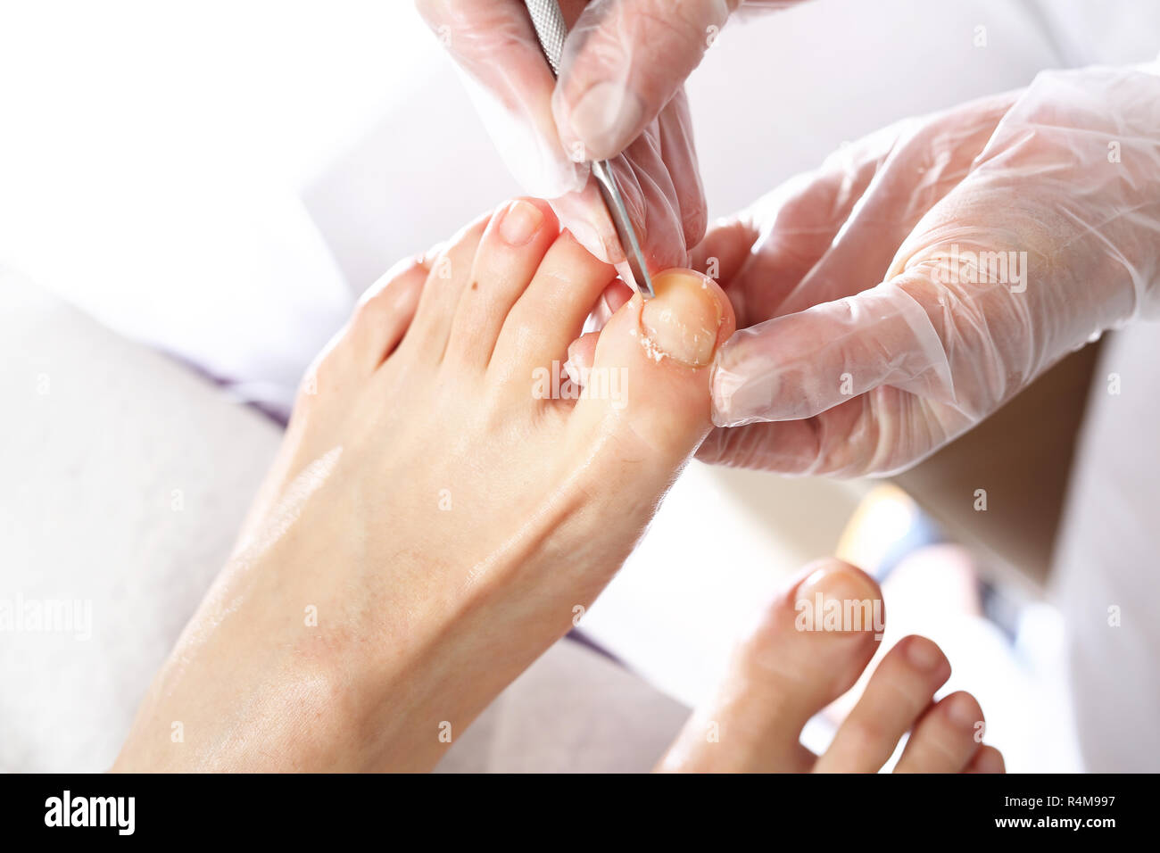 nail cleaning in the beauty salon pedicure. nail clipping at the feet. pedicure,cutting skins. beautician performs pedicure,cleans and cuts fingernails at the feet Stock Photo